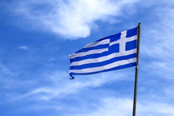 The flag of Greece flies in blue sky. National holiday