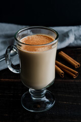 Cozy Almond Rooibos Tea Latte Topped with Cinnamon: A glass mug filled with a tea latte and garnished with sprinkled cinnamon