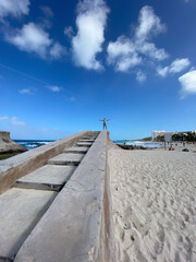 A large concrete staircase and a person thanking nature for the beauty of a beautiful beach on a sunny day, blue sky in a beautiful photo of gratitude