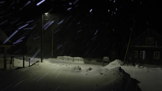 Night winter storm in snowy village in northern region.