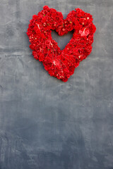 floral heart shaped wreath hanging from a chalkboard wall