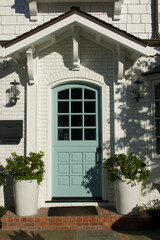 Fototapeta na wymiar quaint little white cottage with a seafoam blue Dutch door