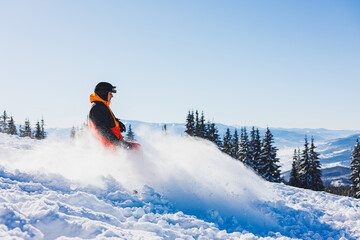 A snowboarder walks down a snowy slope in winter on the snow. Snowboarding, winter freeride