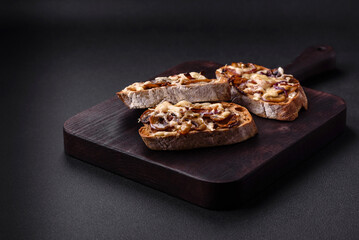 Delicious crispy toast or bruschetta with fried onion, champignon mushrooms and cheese