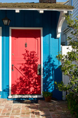 Fototapeta na wymiar charming blue beach cottage with bright red front door