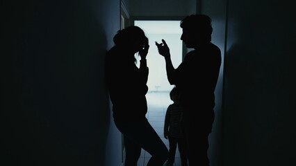 Silhouette of couple standing in corridor in crisis. Parents with child feeling worry and anxiety. Husband and wife discussing difficult situation