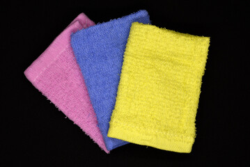 Terry towels on a dark background. Colorful wiping cloths. Terry napkins.