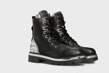 Blank black women's fashion Combat Chelsea boots isolated on white background. Female classic spring autumn shoes in snake skin leather print. Casual lace up, laced footwear. Mock up, template