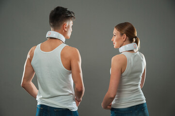 A woman and a man demonstrate an electronic neck massager. Modern technological massager.
