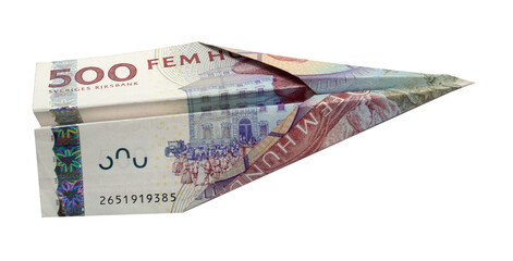 Money plane. Cash Swedish krona banknote folded into airplane isolated on white background. Express...