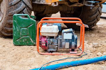 Mobile petrol power generator and jerry can with petrol on the building site