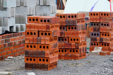 Red bricks and concrete blocks delivered on construction site and placed next to place of work...