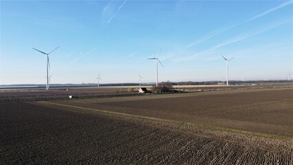 Farmland with farmer's farm. Bare agricultural landscape of food industry in winter season. Windmills in the background Environment and green environment nature landscape of the countryside.