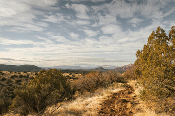 Hiking trail at the popular Airport Mesa loop hike in Sedona Arizona USA southwest during the day with beautiful clouds in the sky looking west.