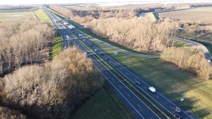 Highway seen from the air in the Netherlands captured with drone. Travel and move, connection with traffic jam and passage with progress. Safety on asphalt with entrance and exit.