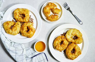 traditional Algerian fried baked  donuts or pancake named Sfenj with honey bowl