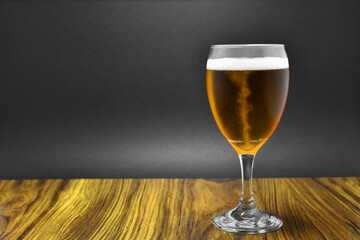 Vaso de Cerveza, servido en una mesa. Espacio para texto al lado izquierdo.