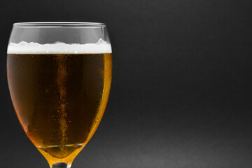 Cerveza Clara aislada en un fondo negro, espacio para texto al lado derecho.