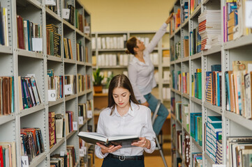Two young female students in a public library. 