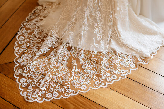 La tra&icirc;ne de la robe de mari&eacute;e sur le parquet