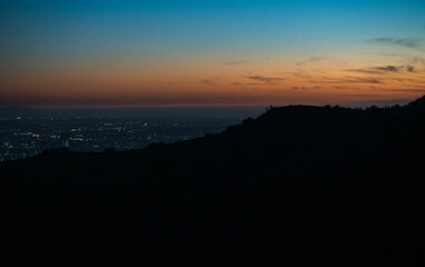 Dusk in Los Angeles, seeing all of the twinkling lights on the horizon. Post sunset background view from Runyon Canyon, California