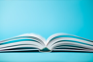 Open white book on a turquoise background