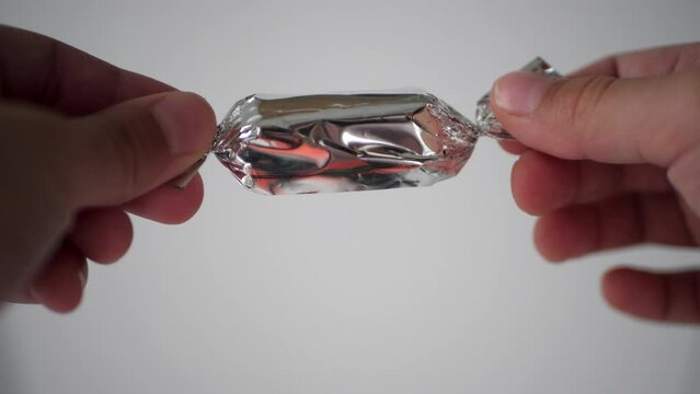 Kids hands unwrapping chocolate candy