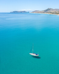 Aerial view of sailing yacht at Porto Santo Island. Shadow under the sea. Clean and clear turquoise water.