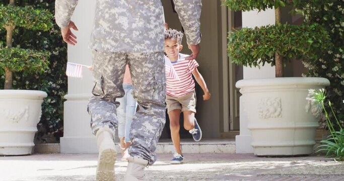 African american male soldier returning home, greeted by happy son and daughter, slow motion