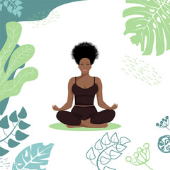 Obraz na płótnie Canvas A beautiful African American girl sits in the lotus position among tropical leaves. A healthy way of life.