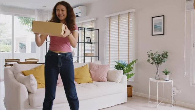 Asia people young Gen Z woman smile carry parcel box goods carton packaging happy joy fun dance at home. Omni channel enjoy buy gift order postal at retail online shop store fast courier send service.