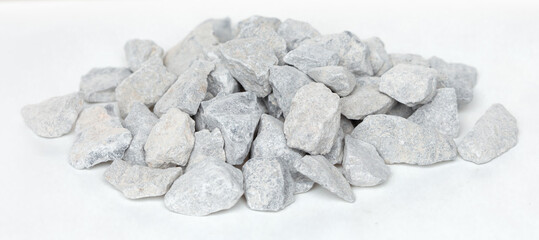 Pile of construction gravel stone lie in group, gray rock gravel show close up texture and dust, object design. White background isolated freeze shot