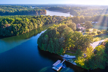 Aerial view of a foggy morning sunrise over lakefront luxury family homes and a  boat dock on Tims Ford Lake in Tennessee.