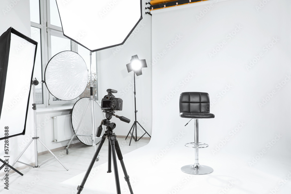 Canvas Prints Tripod with camera, bar stool and professional lighting equipment in modern photo studio