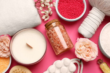 Fototapeta na wymiar Sea salt and different spa products on pink background, flat lay