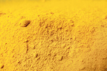 Aromatic turmeric powder as background, closeup view