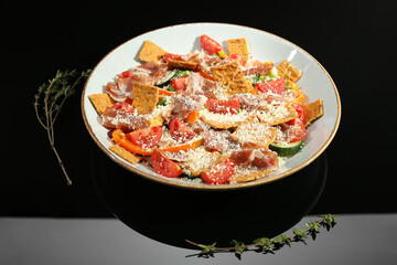 Beautiful composition of salad with prosciutto on black table in studio. Food stylist