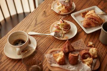나무 테이블 위에 놓인 커피와 베이커리 디저트 빵