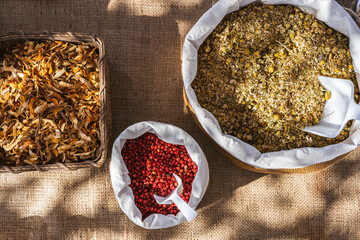 Top view of several rustic baskets with spices for the preparation of aromatic essences. Chamomile, red pepper and dried orange peel. Aromatherapy.