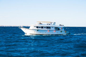 Fototapeta na wymiar pleasure boat, yacht sailing on the blue sea with passengers.