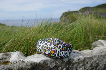 Obraz premium Ancient stone wall by cliff with painted rock and you rock message