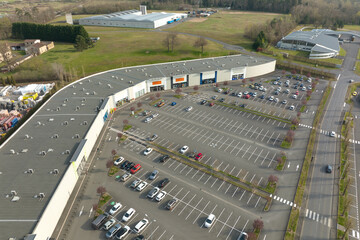 Aerial view of many colorful cars parked on parking lot with lines and markings for parking places and directions