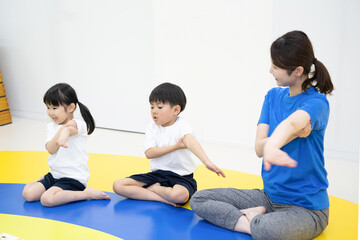 Children and teachers exercising indoors