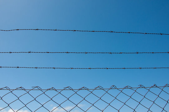 barbed wire fence with blue sky as background
