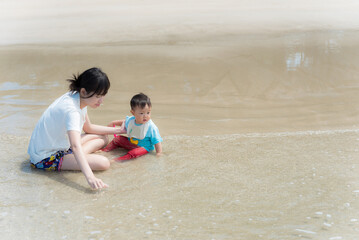 Fototapeta na wymiar Happiness asia mother and baby on the beach ,asian family at sea