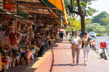  Happy Asian family mother and daughter holding flower bouquet and walking together during shopping at florist shop street market for flowers vase arrangement celebrating holiday event at home.