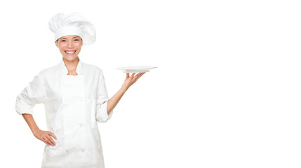 Chef showing empty plate. Happy smiling portrait of female in chef uniform and chef hat isolated cutout PNG on transparent background. Asian Caucasian woman model.