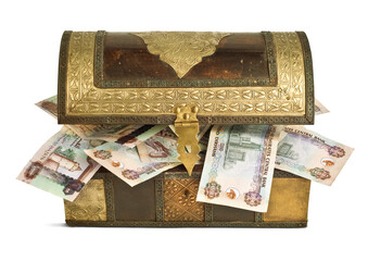 UAE dirham currency notes stuffed into the vintage wooden trunk or chest. Treasure box filled with United Arab Emirates currency notes.