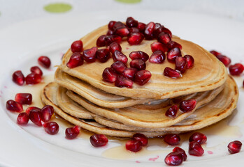 
Oatmeal pancakes with pomegranate, jam and maple syrup.