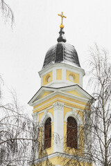 White and yellow church tower, winter landscape. Architecture, nature